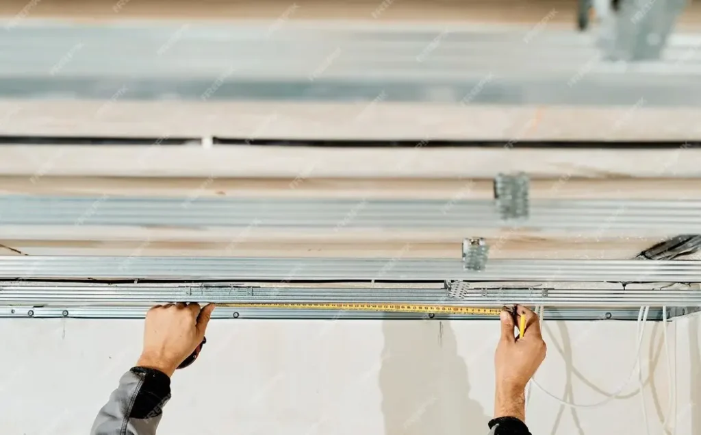 measuring tape and other materials to install cable tray on wall